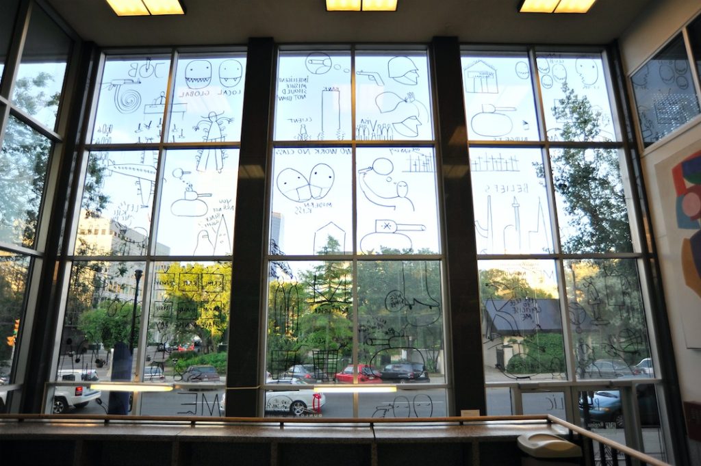 Dan Perjovschi, The Public Drawing, 2009, black marker pen on east and north glass panels, exterior of Regina Public Library building, Various dimensions, Courtesy of the artist and Lombard Fried Projects, New York